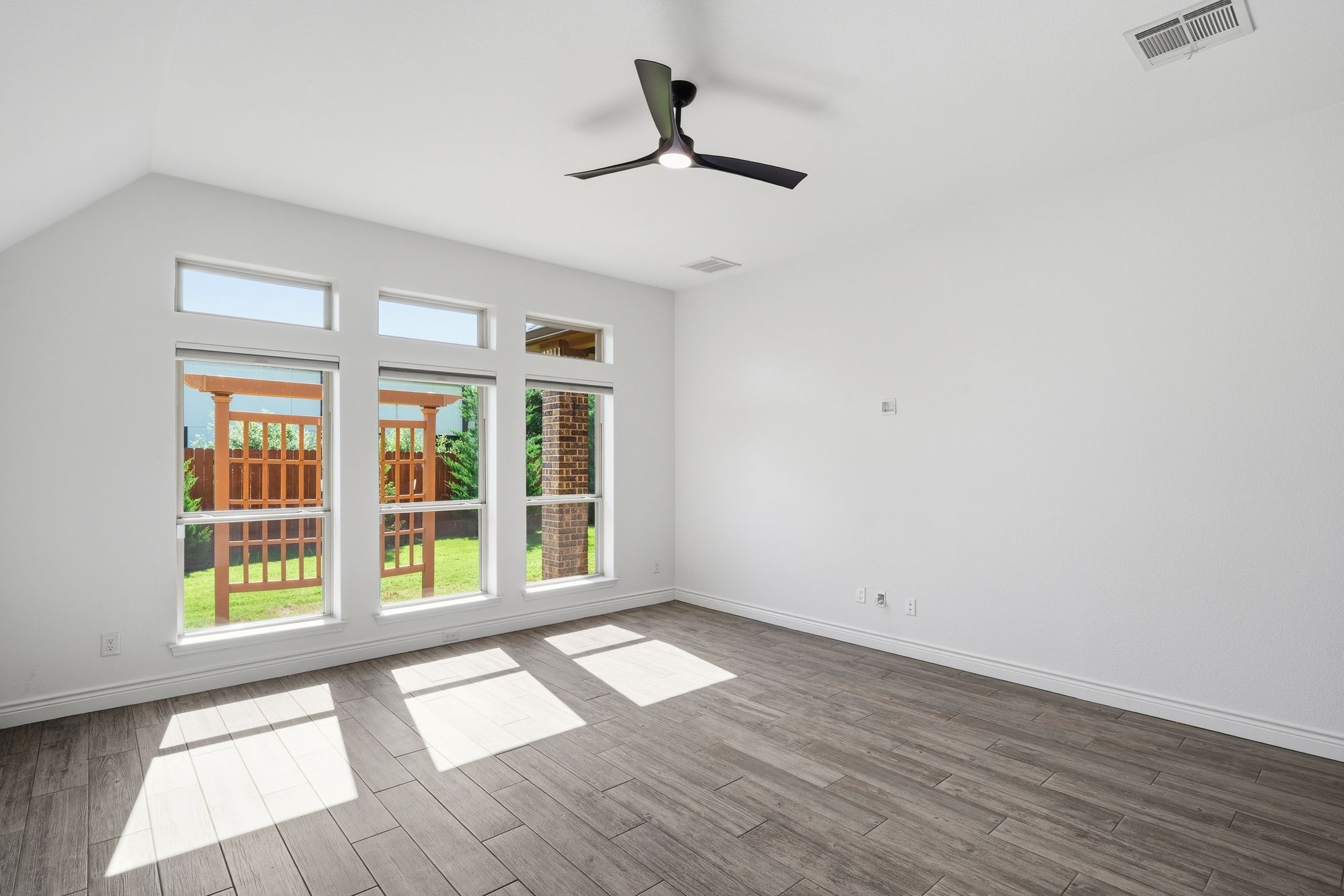 Bedroom with transom windows over the backyard