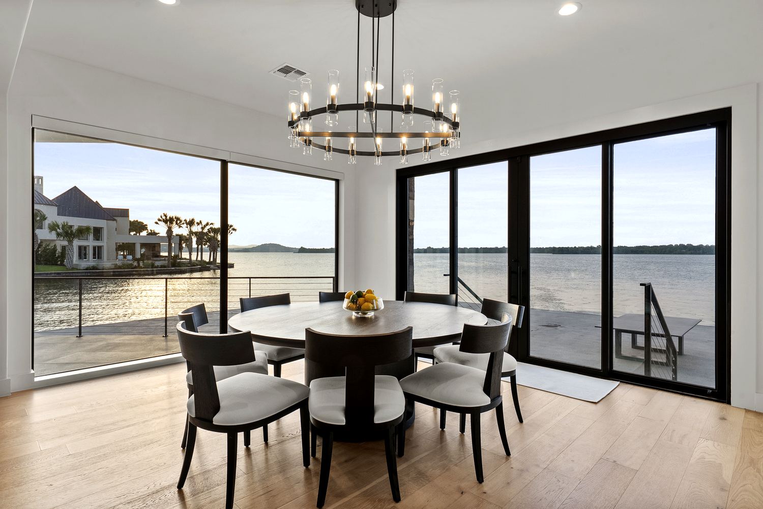 Dining beneath a statement chandelier with lake views