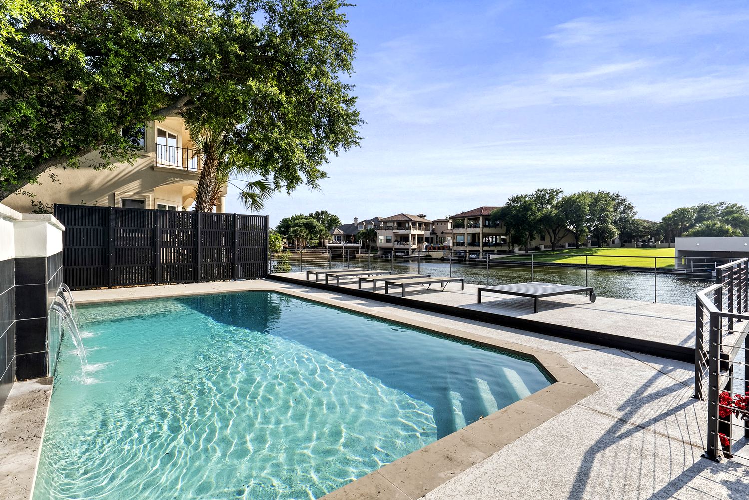 Resort pool with deck jets and tanning ledge over open water