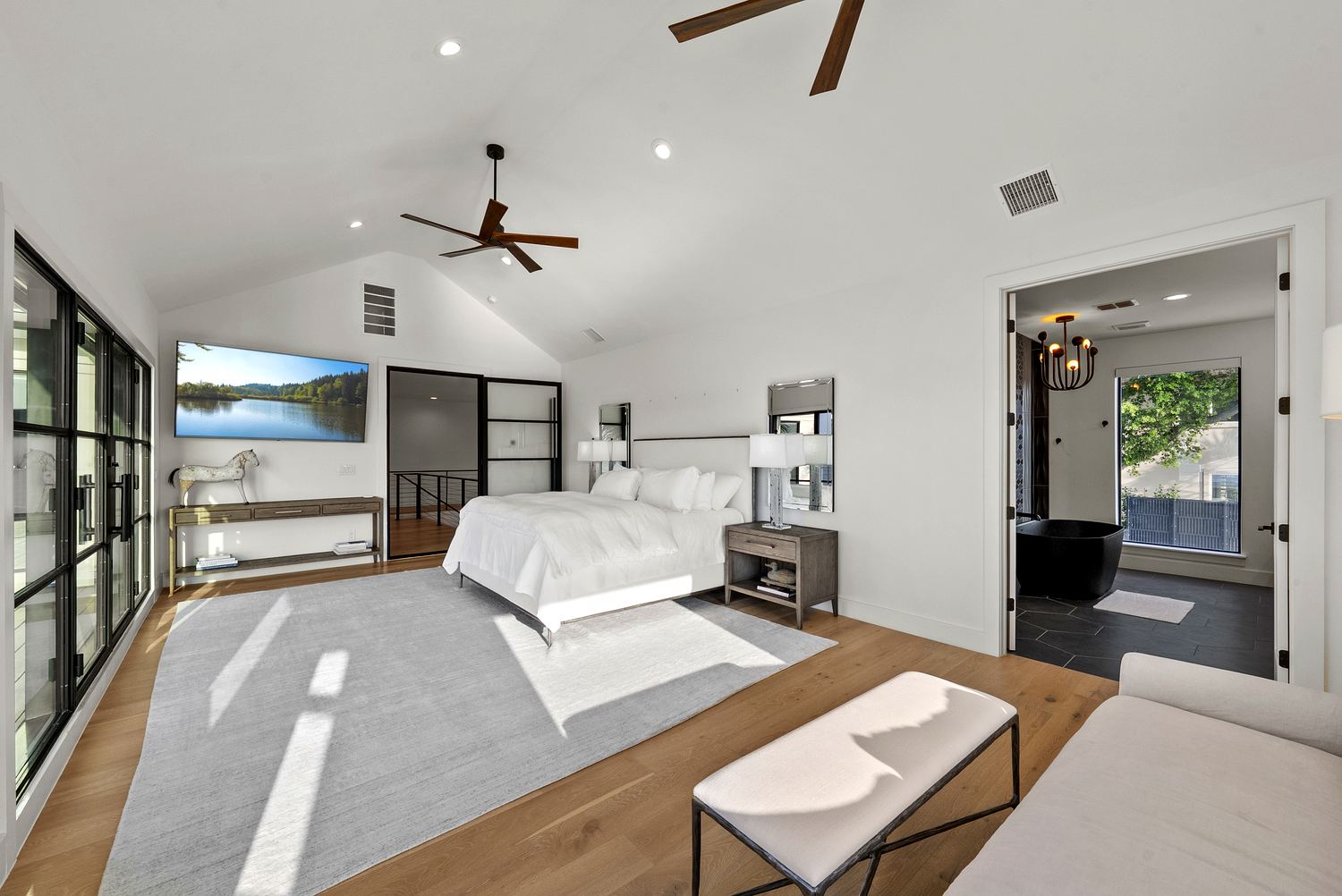 Master suite ensuite with oak vanity, matte-black fixtures and lake views beyond